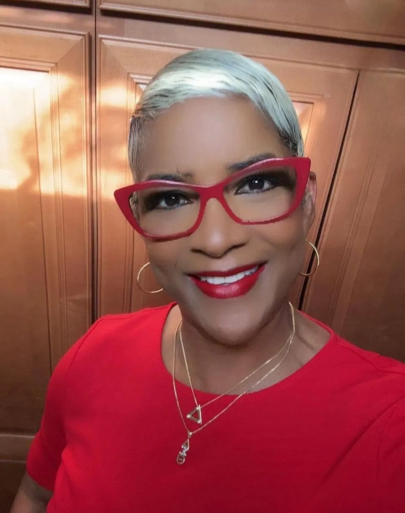 A woman with red glasses and blue hair.