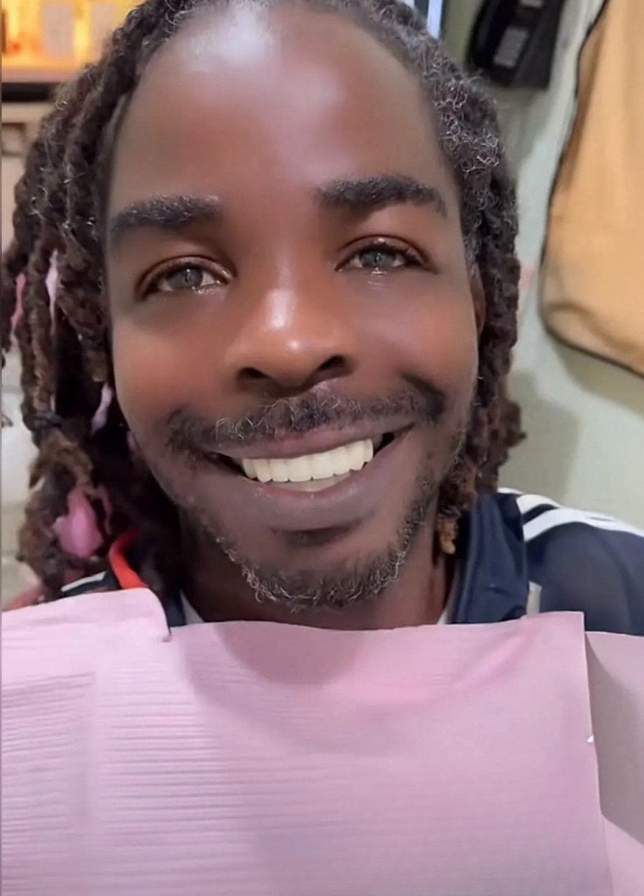 A man with dreadlocks smiles for the camera.