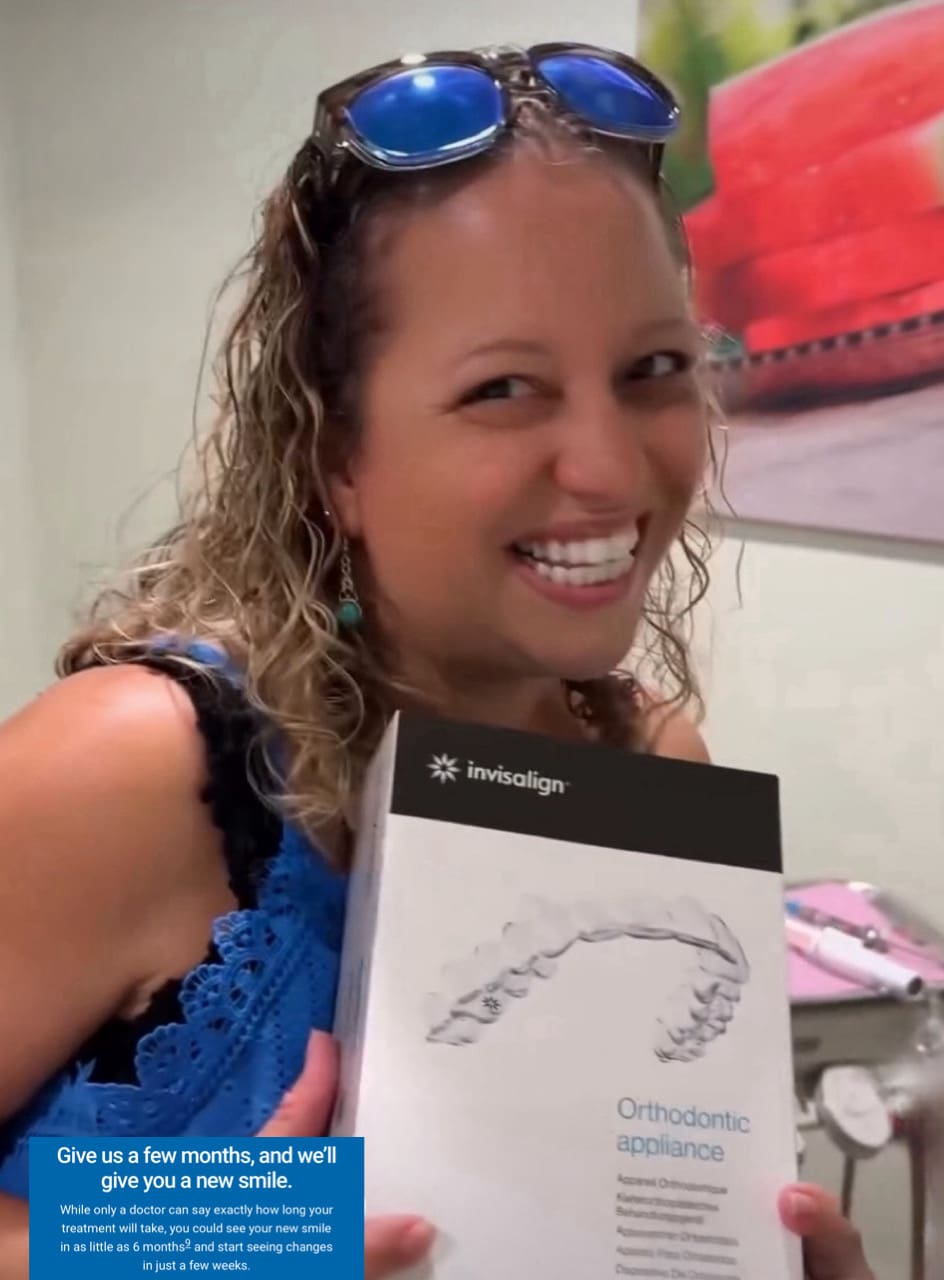 A woman holding up an open box of electronics.